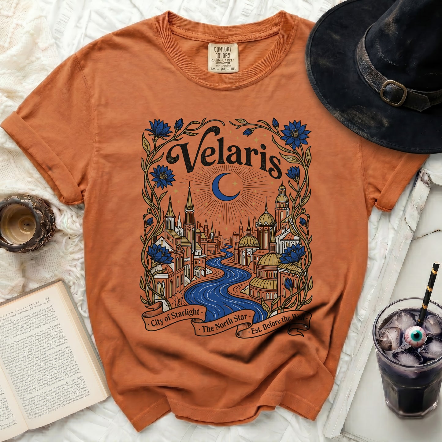 Orange t-shirt with a "Velaris City of Starlight The North Star Est. Before the Wall" graphic.