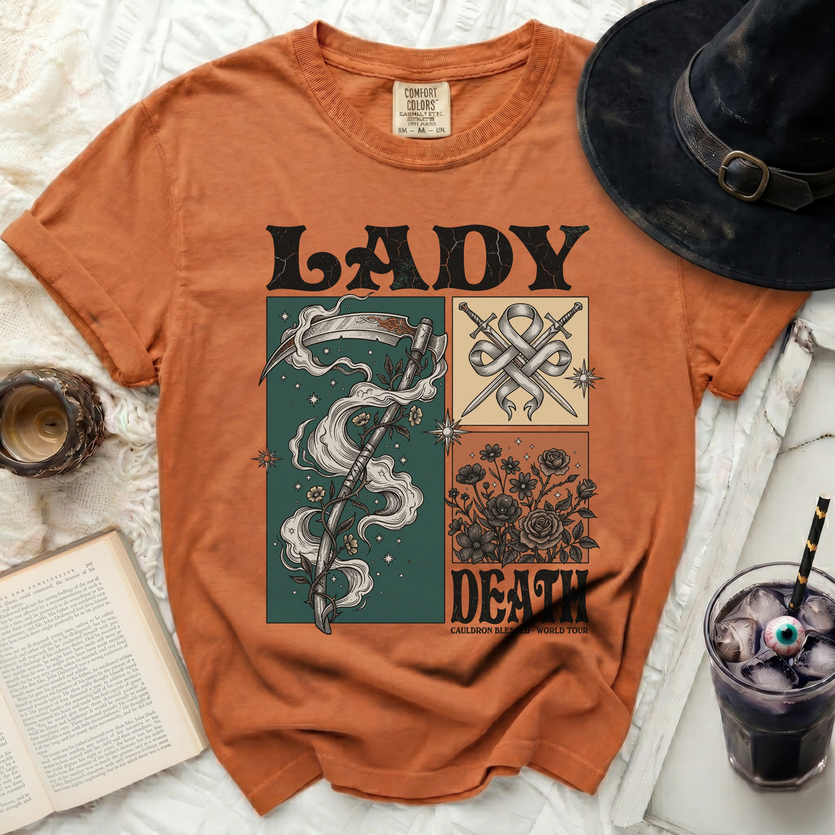Orange t-shirt with Lady Death graphic featuring a scythe, swords, and flowers.
