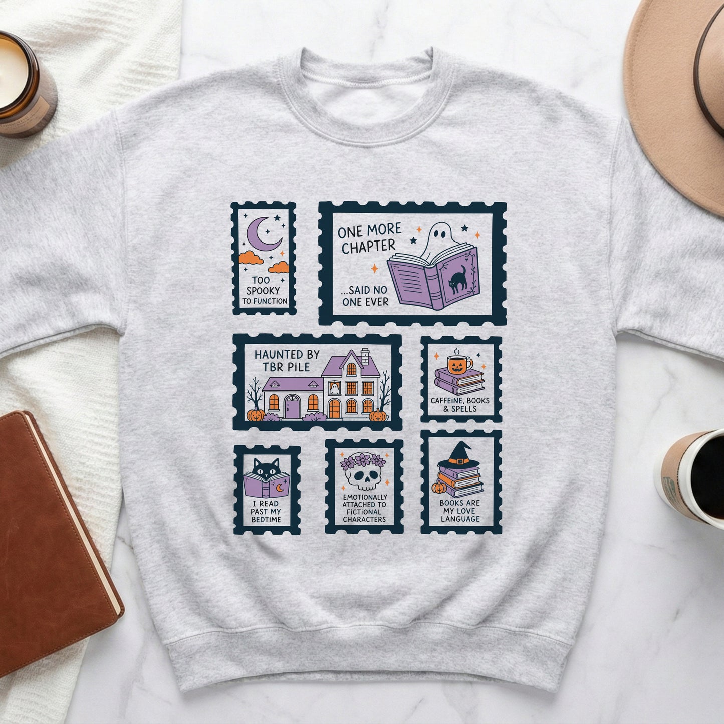 Light gray crewneck sweatshirt with stamp-like graphics featuring spooky and book-themed designs.