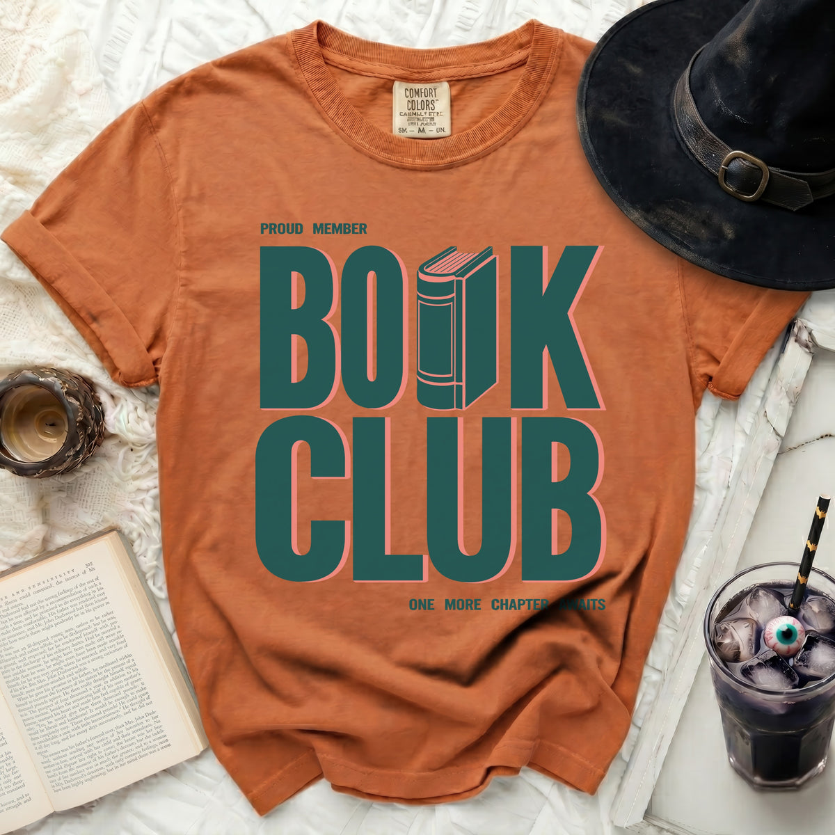 Orange t-shirt with "Proud Member Book Club" graphic and a book image.