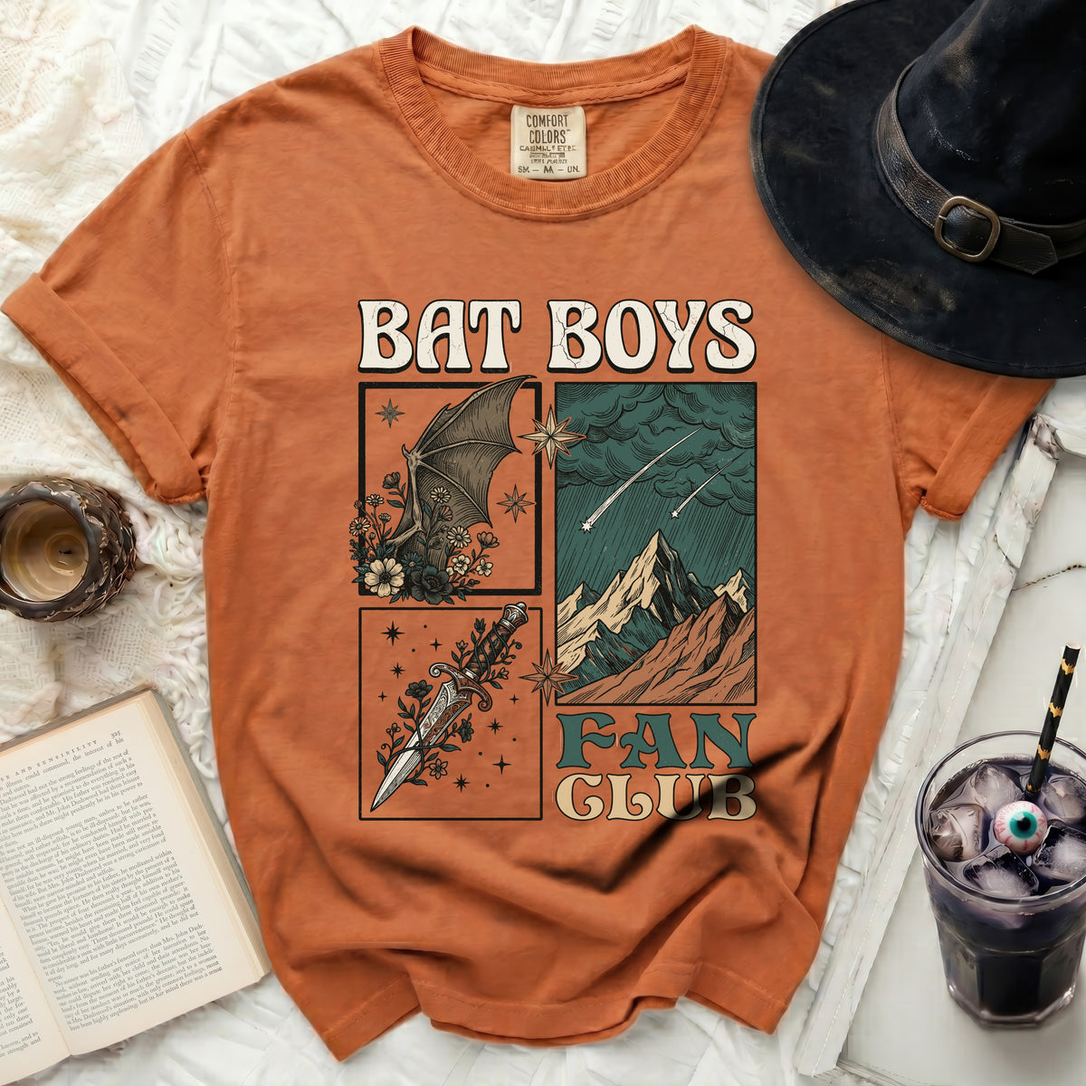 Orange t-shirt with "Bat Boys Fan Club" graphic featuring a bat, dagger, and mountains.
