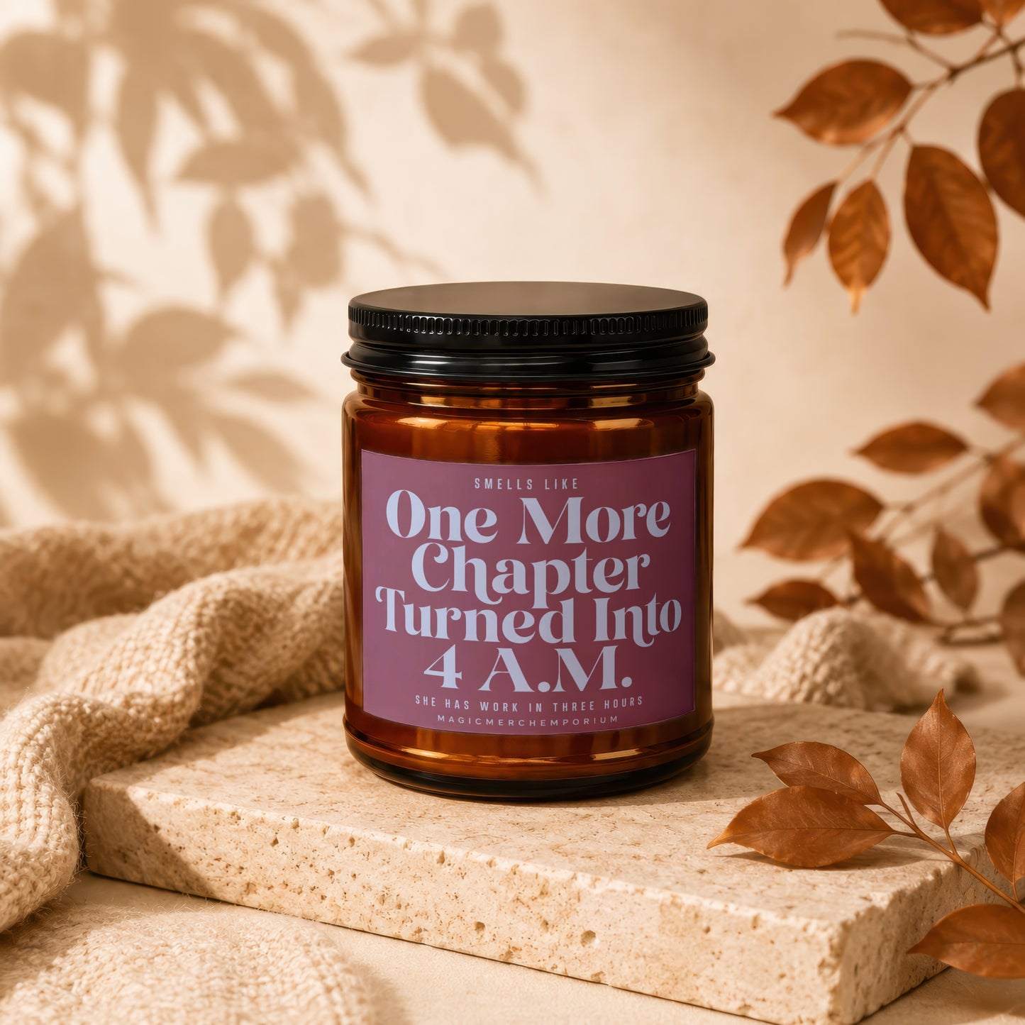 Brown glass candle with black lid, labeled "One More Chapter" with text below.