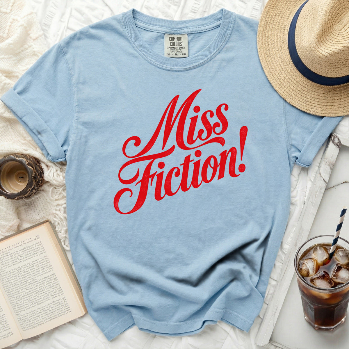 Light blue t-shirt with red "Miss Fiction!" text and Comfort Colors tag.