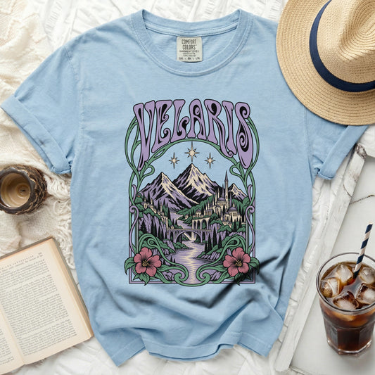 Light blue t-shirt with "VELARIS" in purple text and a fantasy landscape design.