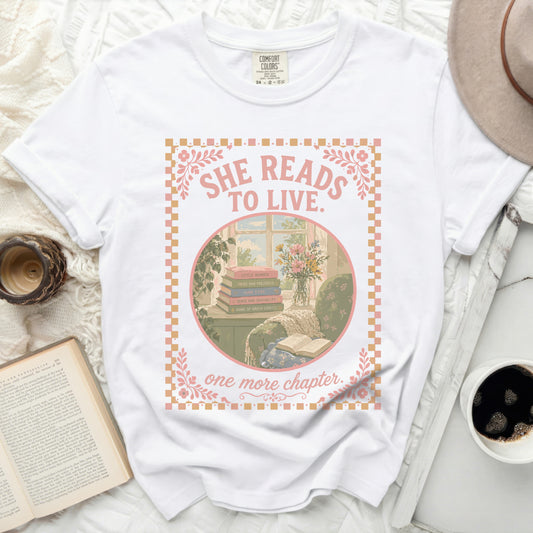 White t-shirt with "She Reads to Live. One More Chapter." and book titles.