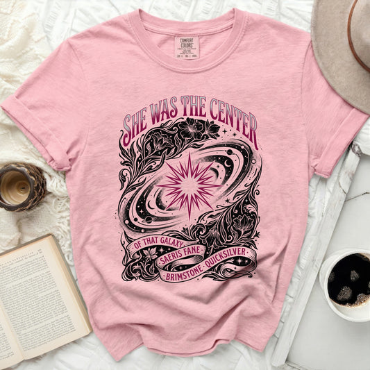 Pink t-shirt with "She was the center of that galaxy" text and celestial design.