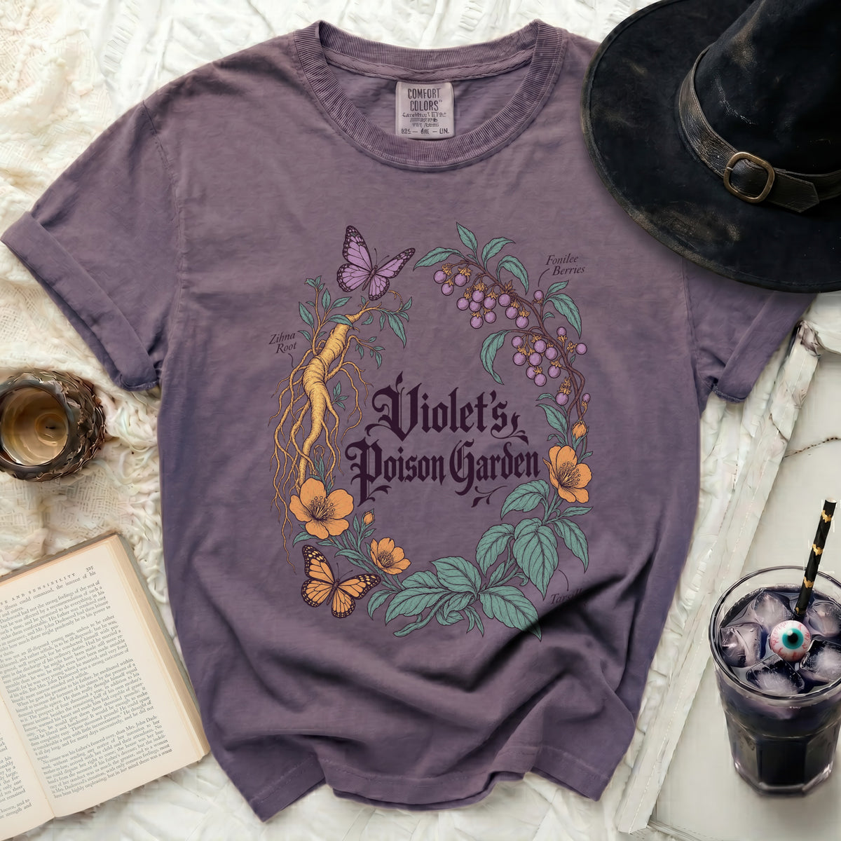 Faded purple t-shirt featuring botanical graphics, butterflies, and text reading Violet's Poison Garden.