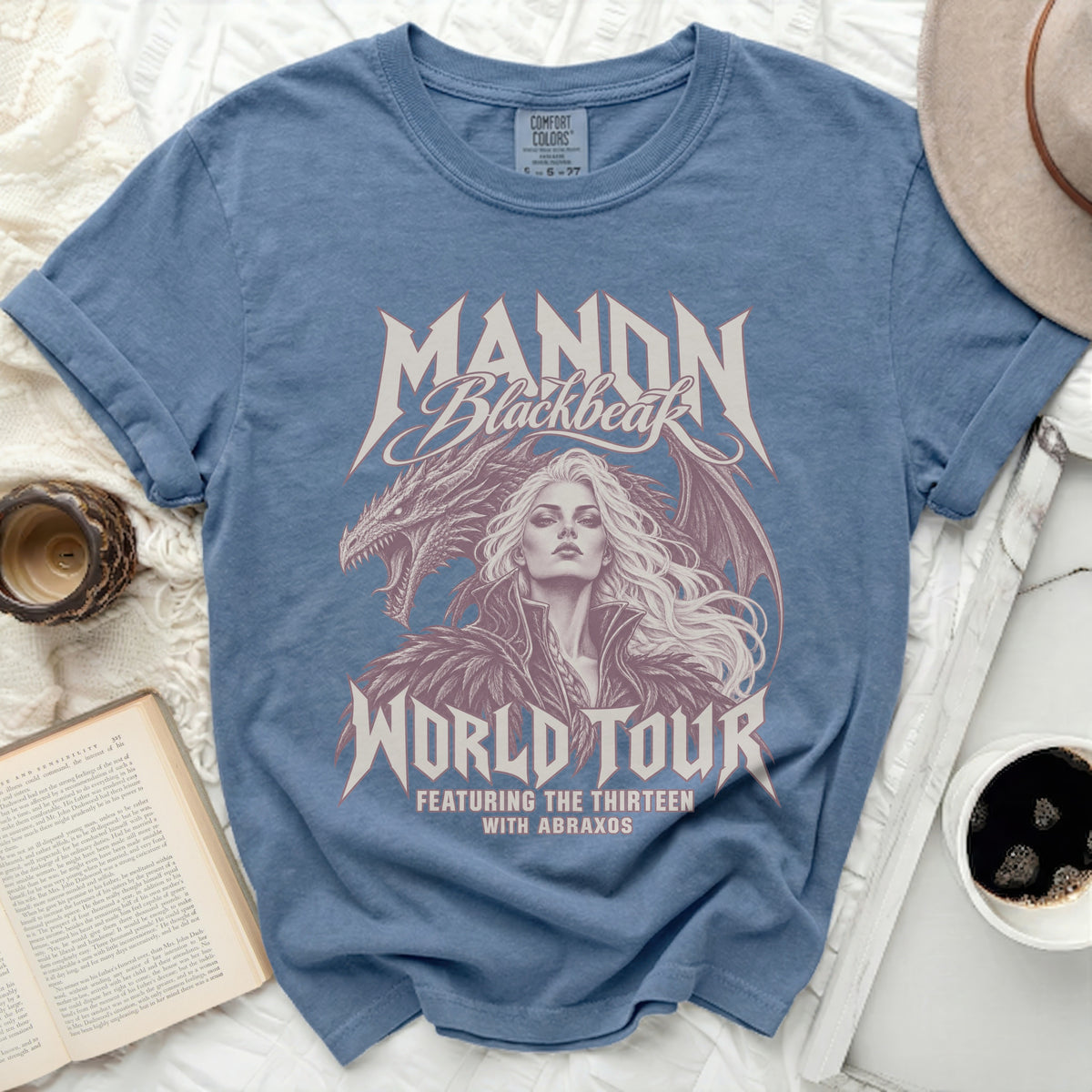 Blue t-shirt with Manon Blackbeak dragon and woman graphic, "World Tour" text.