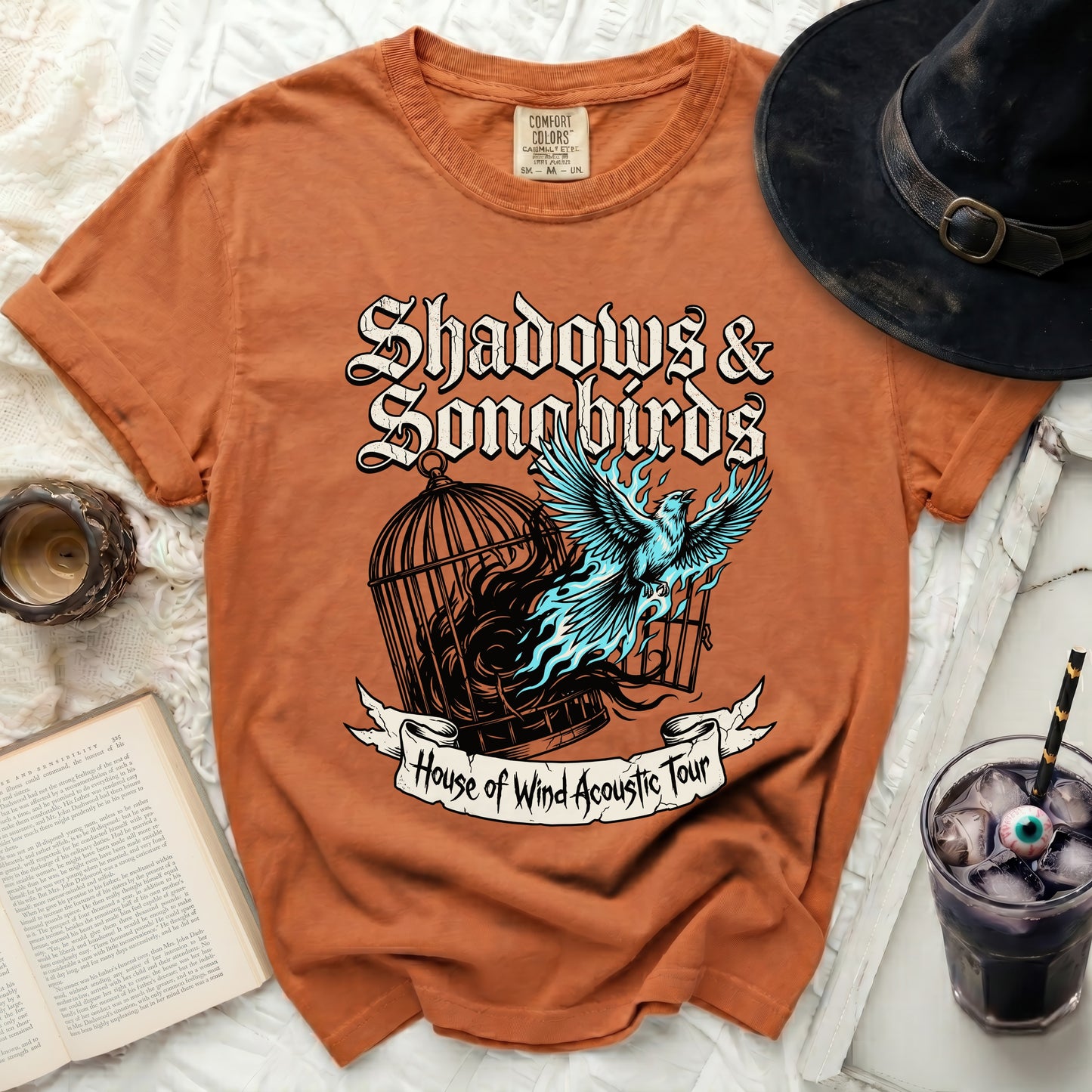 Orange t-shirt with "Shadows & Songbirds" and bird design.