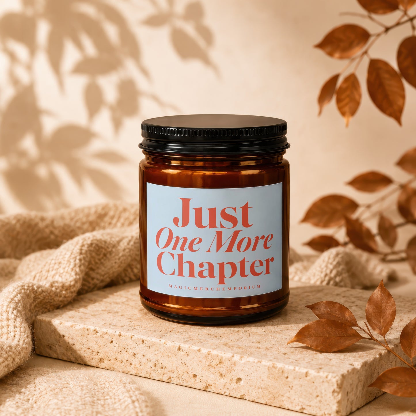 Amber candle with a black lid and a label reading "Just One More Chapter."