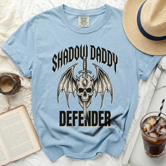 Light blue t-shirt with "Shadow Daddy Defender" skull and wings graphic.