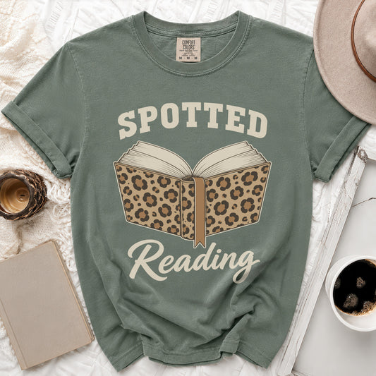 Green t-shirt with "Spotted Reading" text and a leopard print open book graphic.