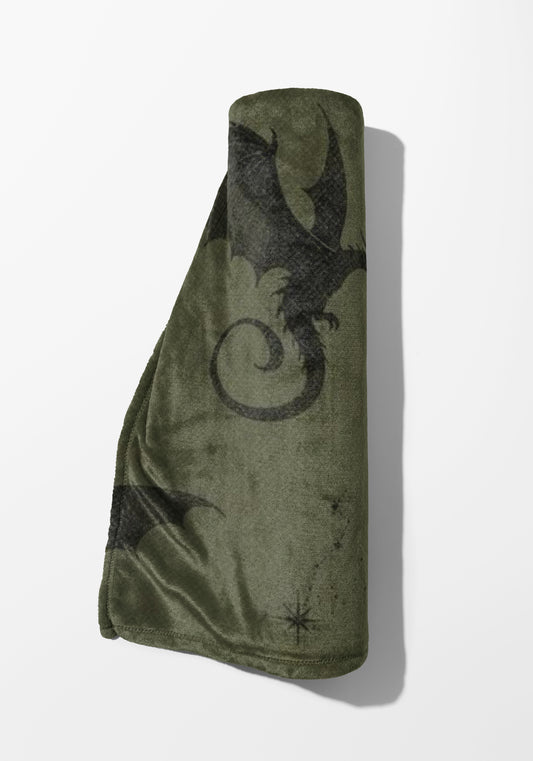 Rolled green fleece blanket with black dragon and star pattern.