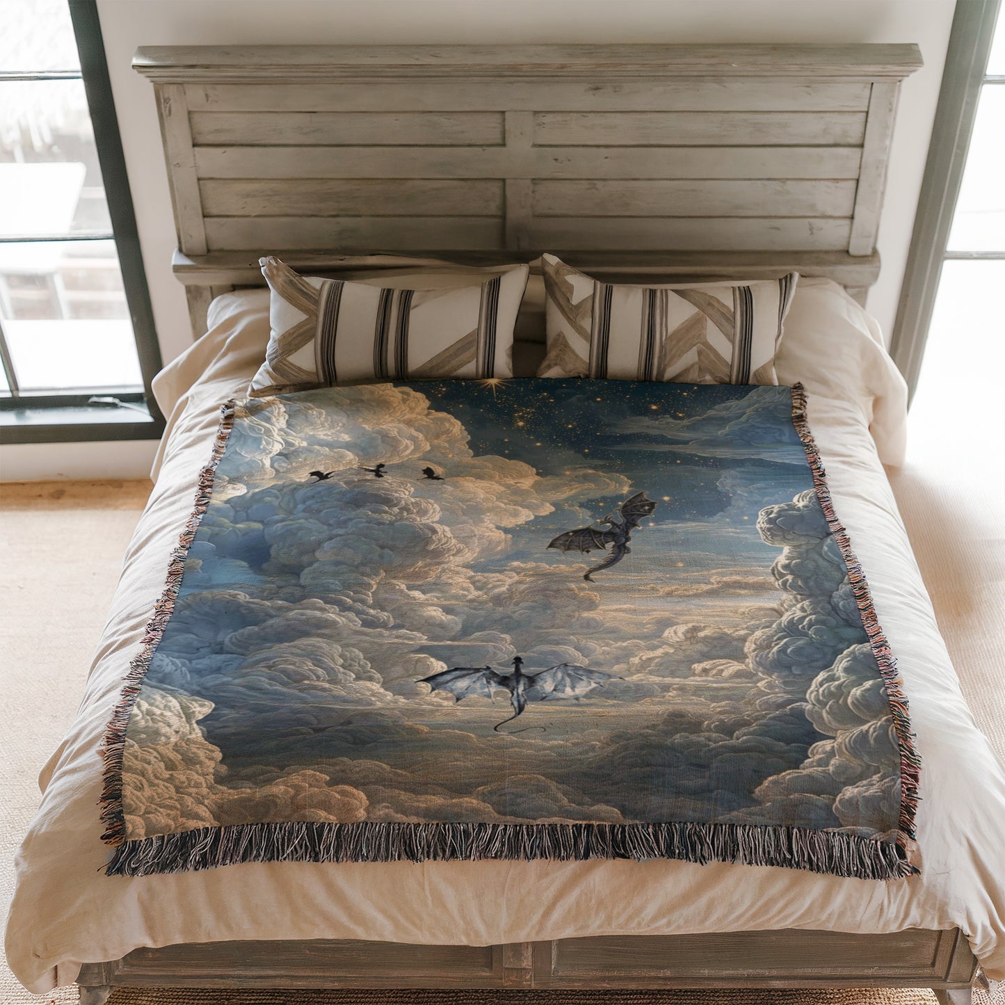 a bedroom with a bed covered in a large, colorful blanket featuring a dragon and clouds. The bed is positioned against a white wall, and there are two pillows on the bed.