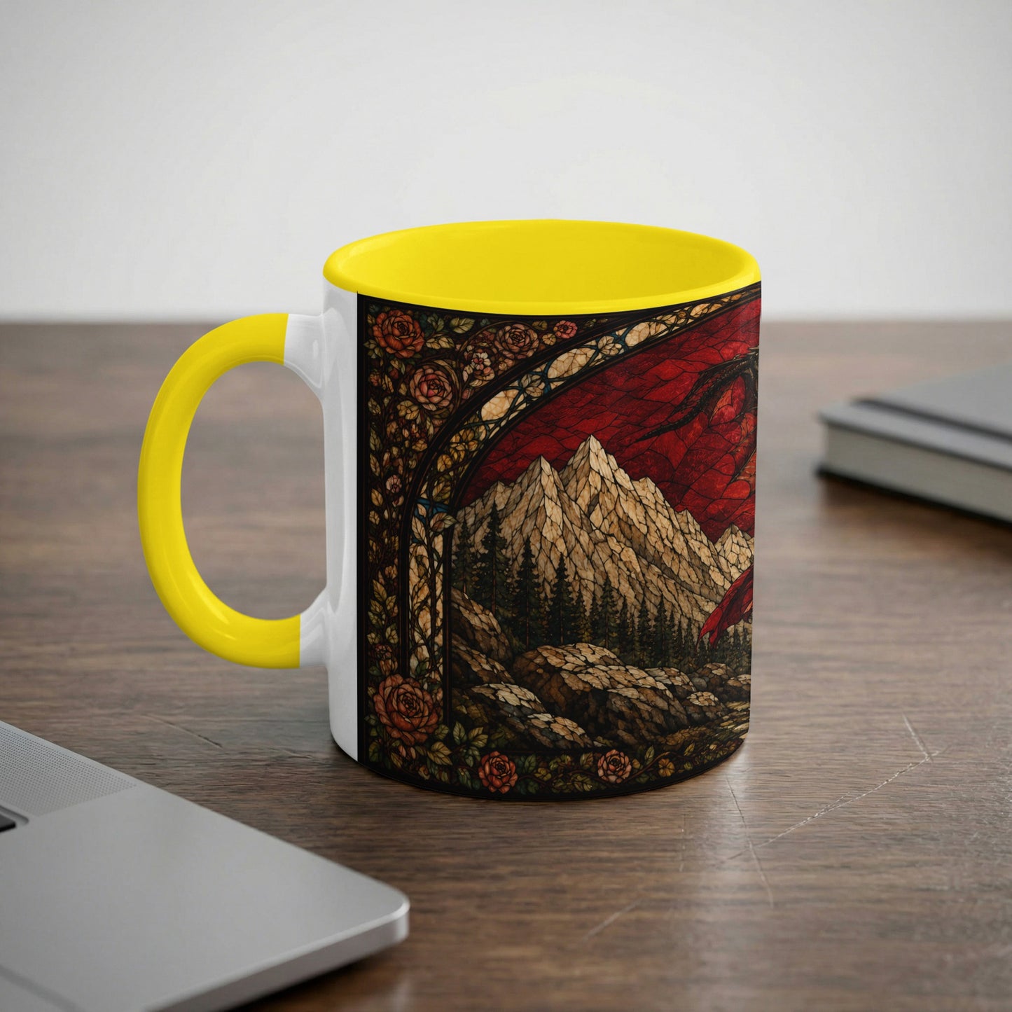 White mug with yellow handle and stained glass art of mountains and a dragon.