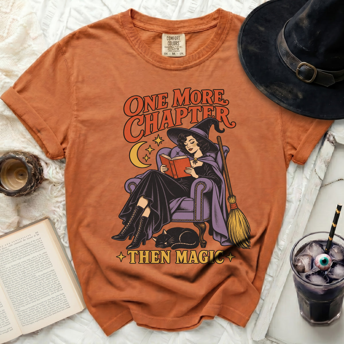 Orange t-shirt with witch reading and text "One More Chapter Then Magic".