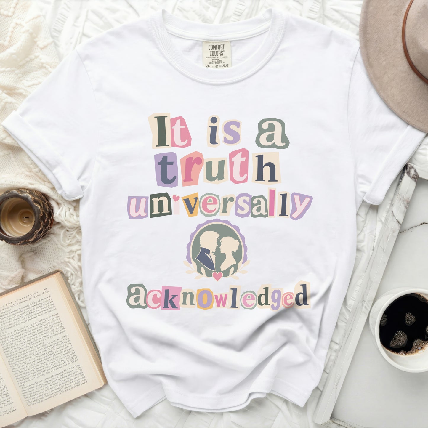 White t-shirt with colorful cut-out letters reading "It is a truth universally acknowledged"