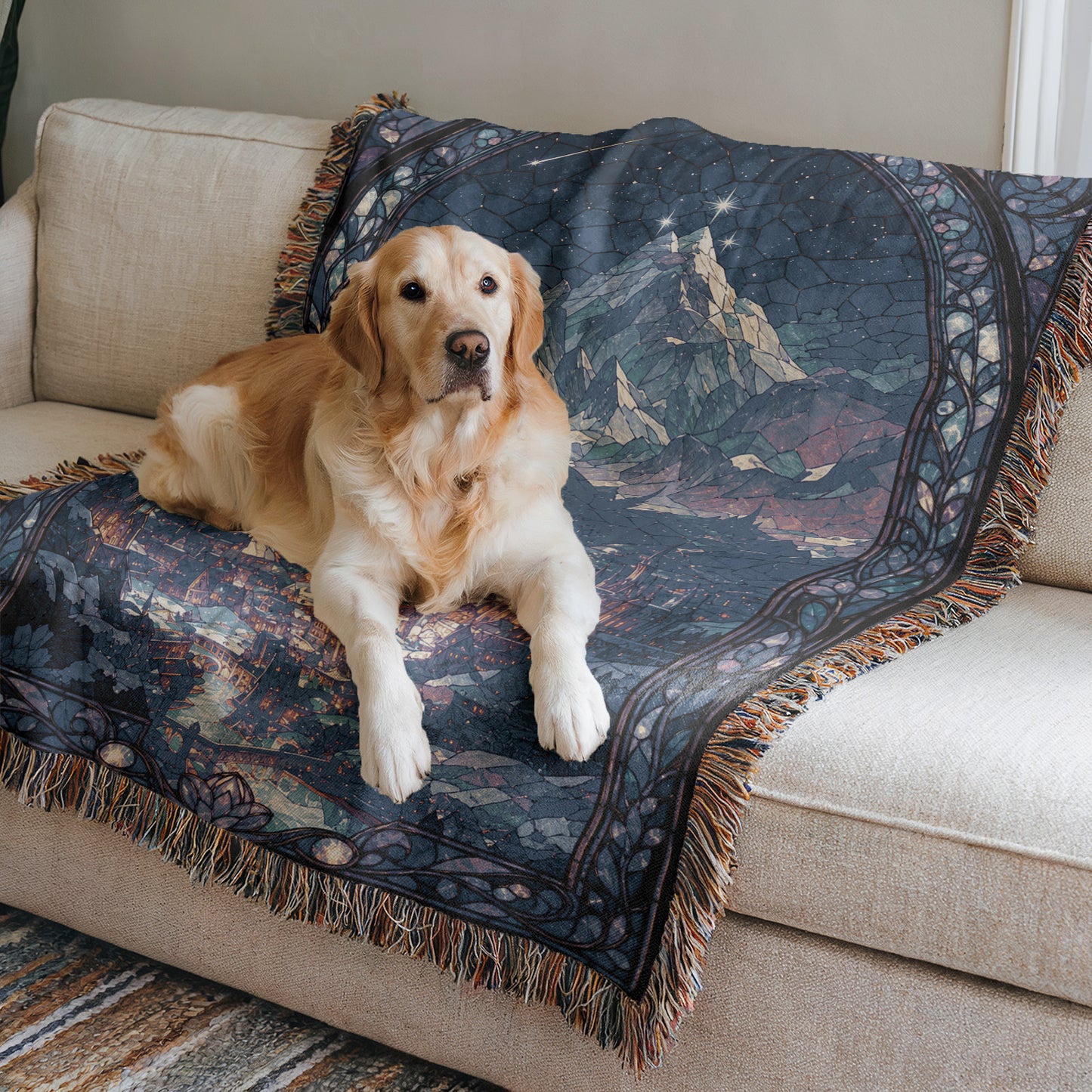 A golden retriever dog is lying on a blue and black patterned blanket on a beige couch.