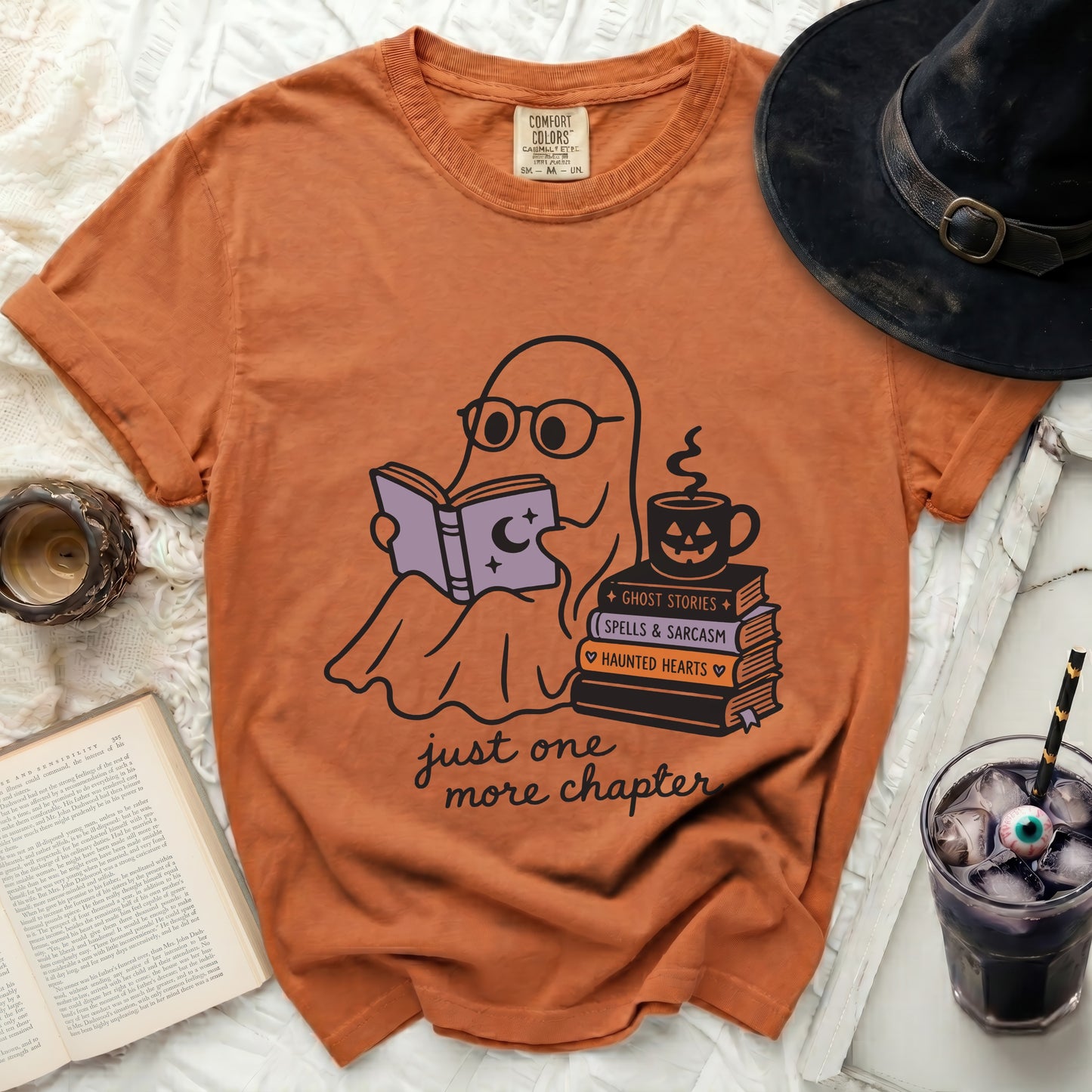 Orange t-shirt with ghost reading book and "just one more chapter" text.