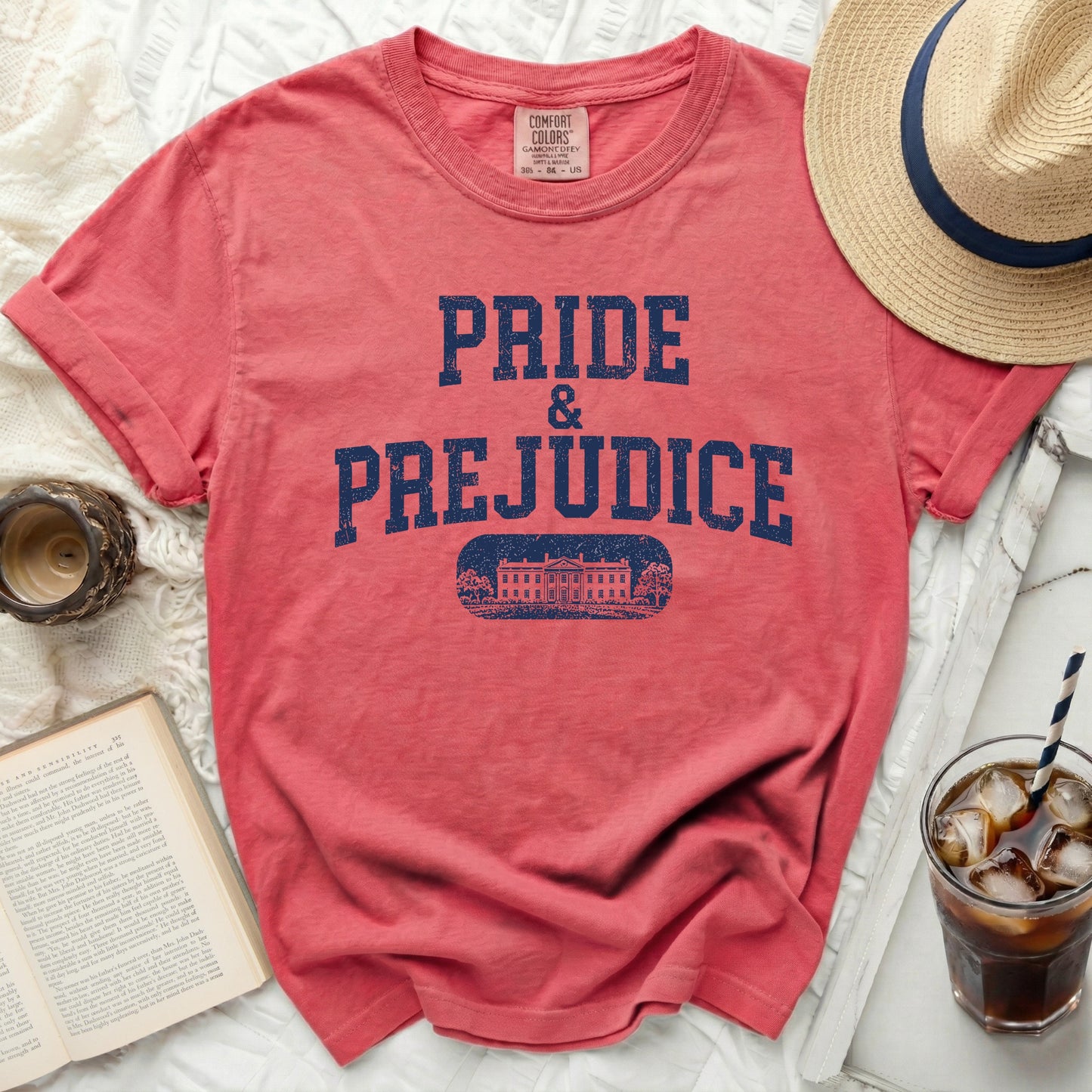 Coral t-shirt with "PRIDE & PREJUDICE" text in distressed navy blue.