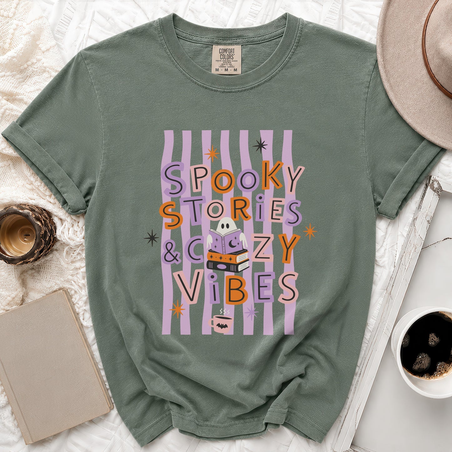 Green t-shirt with "Spooky Stories & Cozy Vibes" text and Halloween-themed graphics.