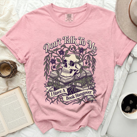 Pink t-shirt with skull, books, vines, and text: "Don't Talk To Me I Have A Book Hangover"