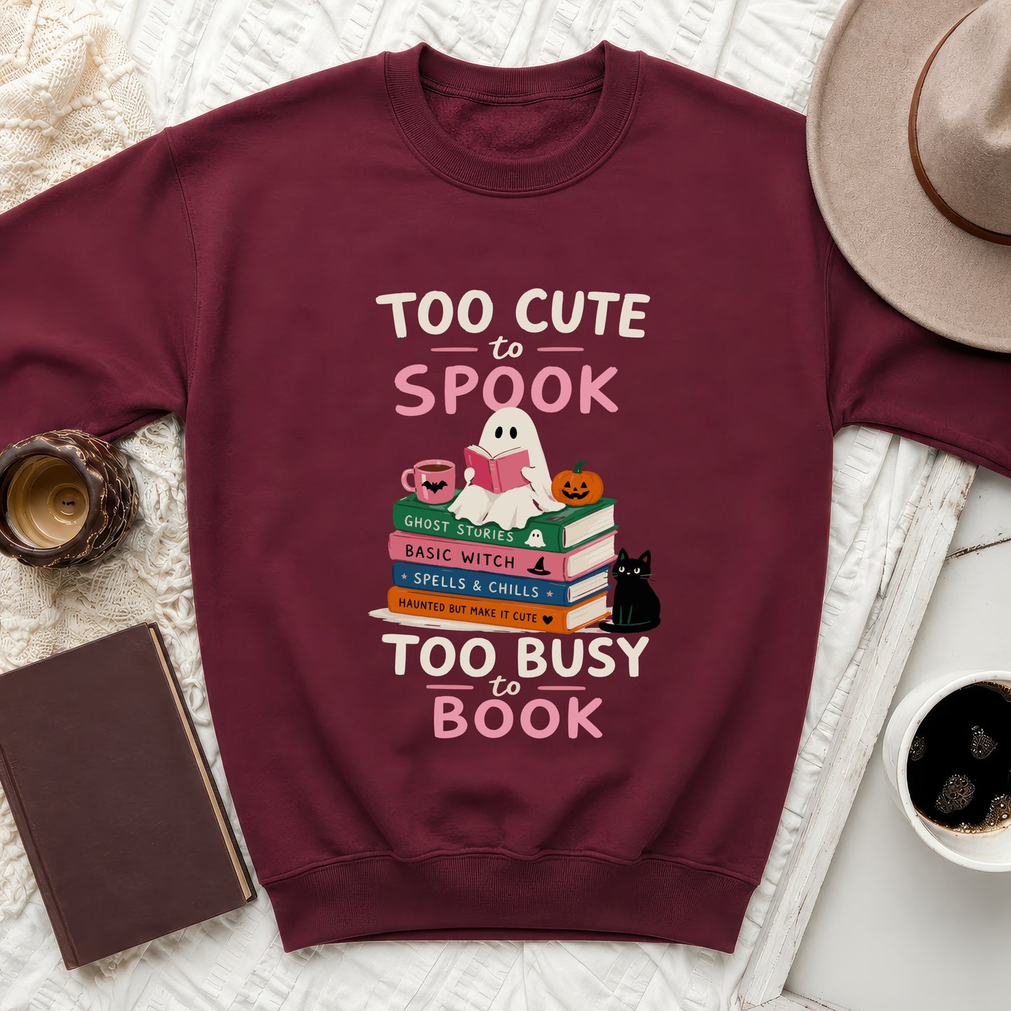 Maroon sweatshirt with "Too Cute to Spook" and "Too Busy to Book" text.