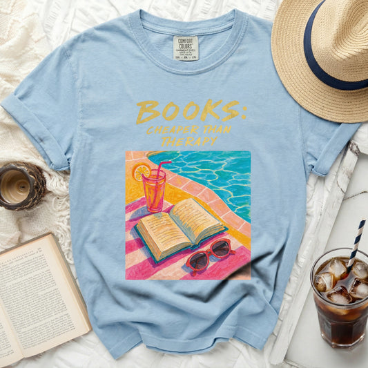 Light blue t-shirt with "Books: Cheaper Than Therapy" text and illustration.