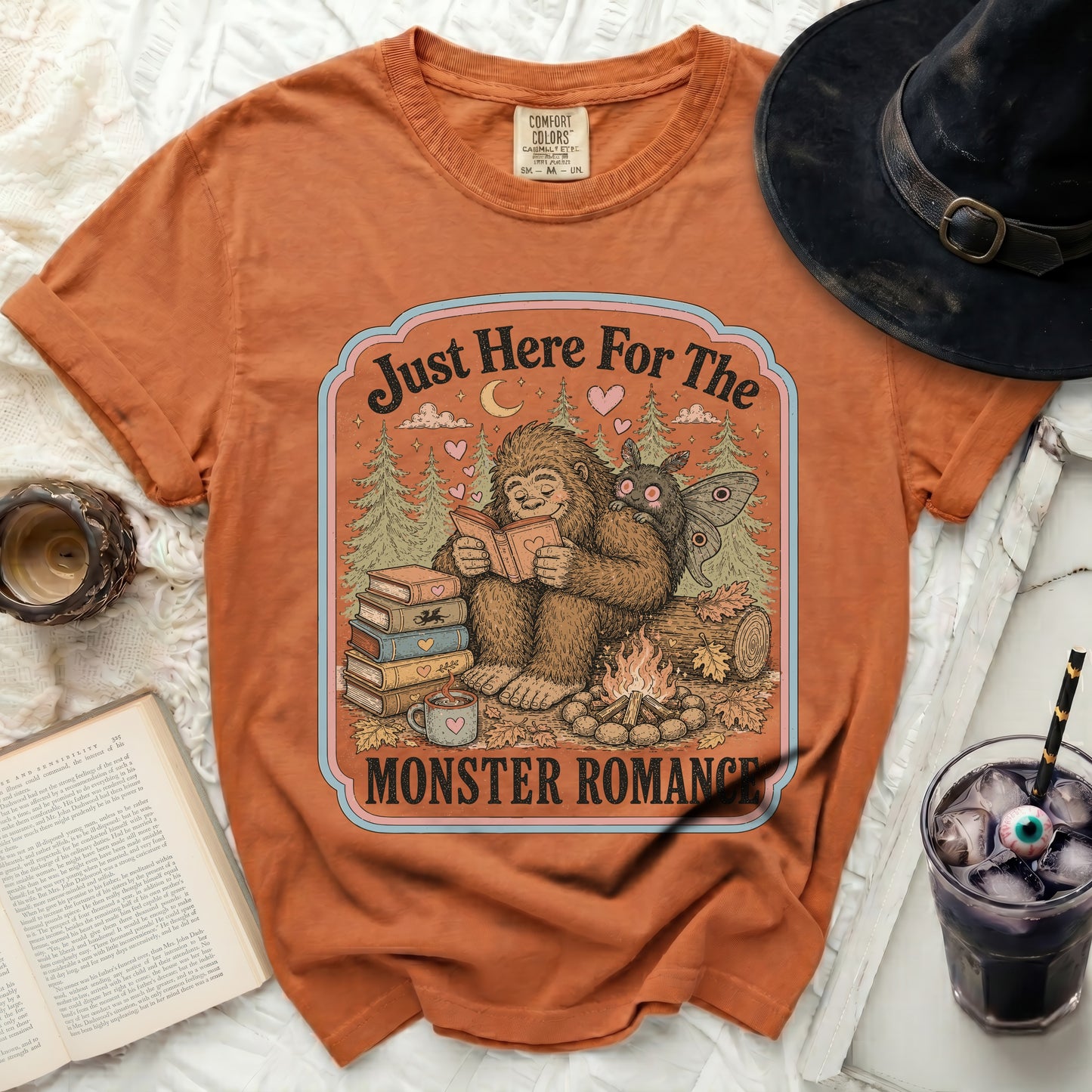 Orange t-shirt with Bigfoot reading to a moth with text "Just Here For The Monster Romance".