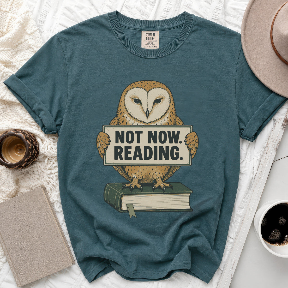 Teal t-shirt with barn owl graphic holding a "Not Now. Reading." sign.