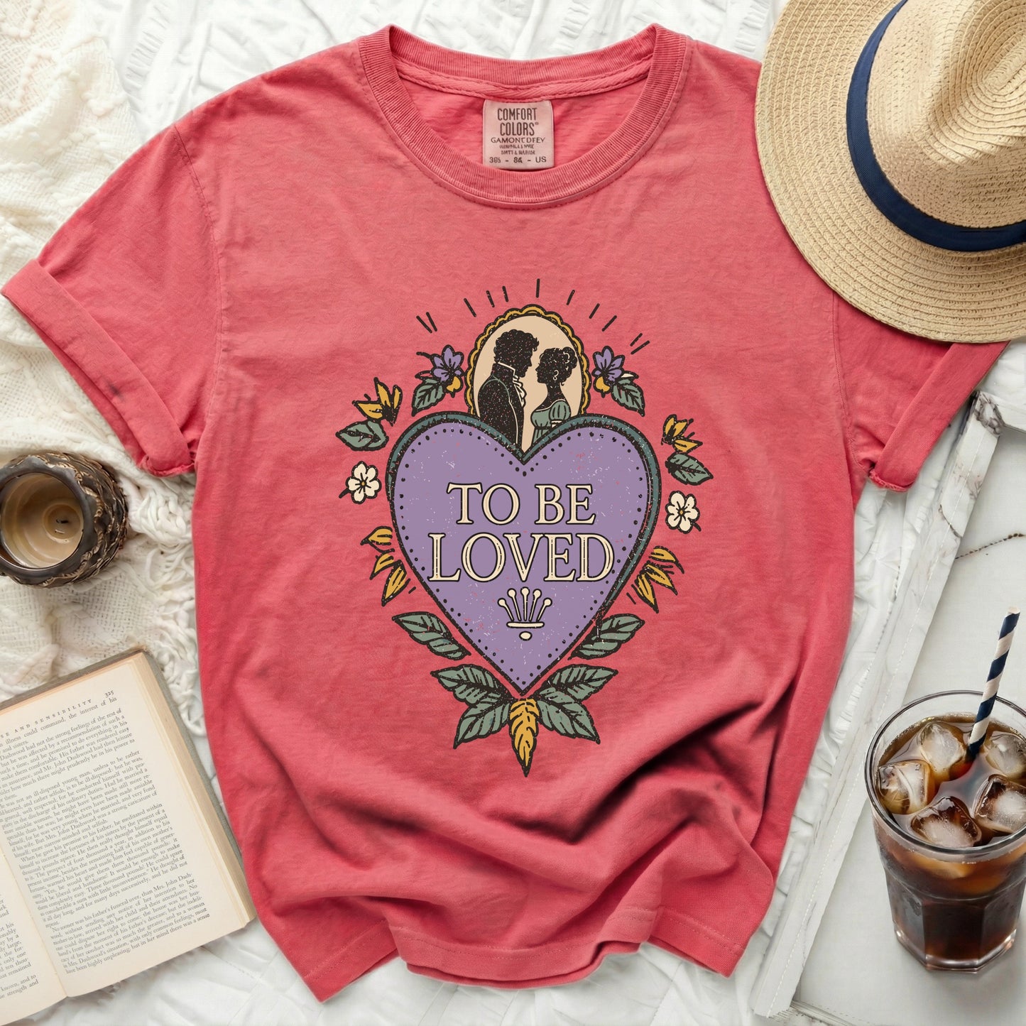Salmon t-shirt with "To Be Loved" graphic featuring a couple and heart.