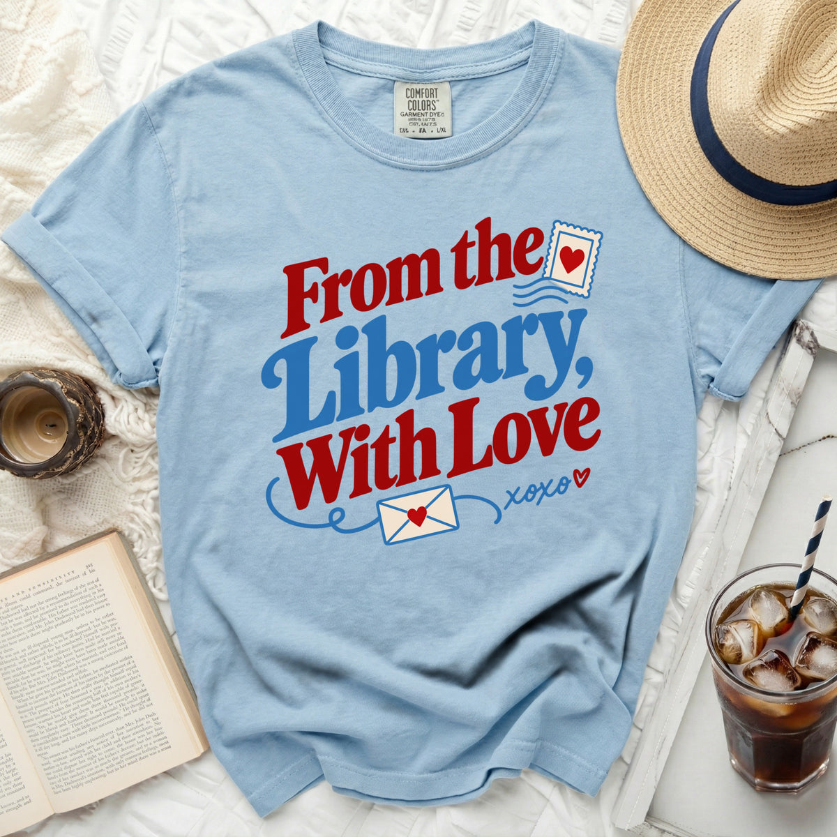 Light blue t-shirt with "From the Library, With Love" text and envelope graphics.