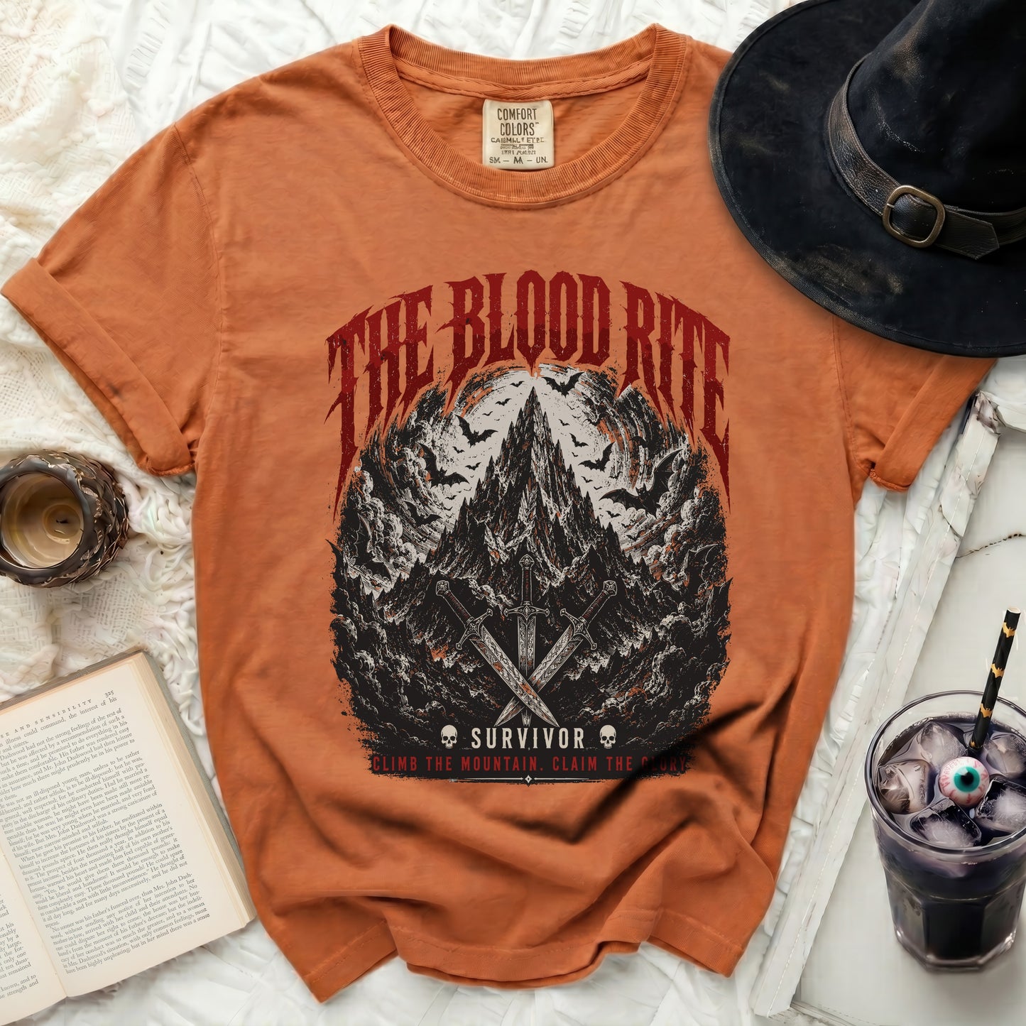Orange t-shirt with "The Blood Rite Survivor" graphic and swords.