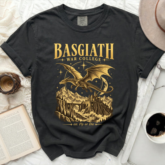 Dark t-shirt with gold graphic of a dragon over mountains and castle, "BASGIATH WAR COLLEGE" and "est. Fly or Die".