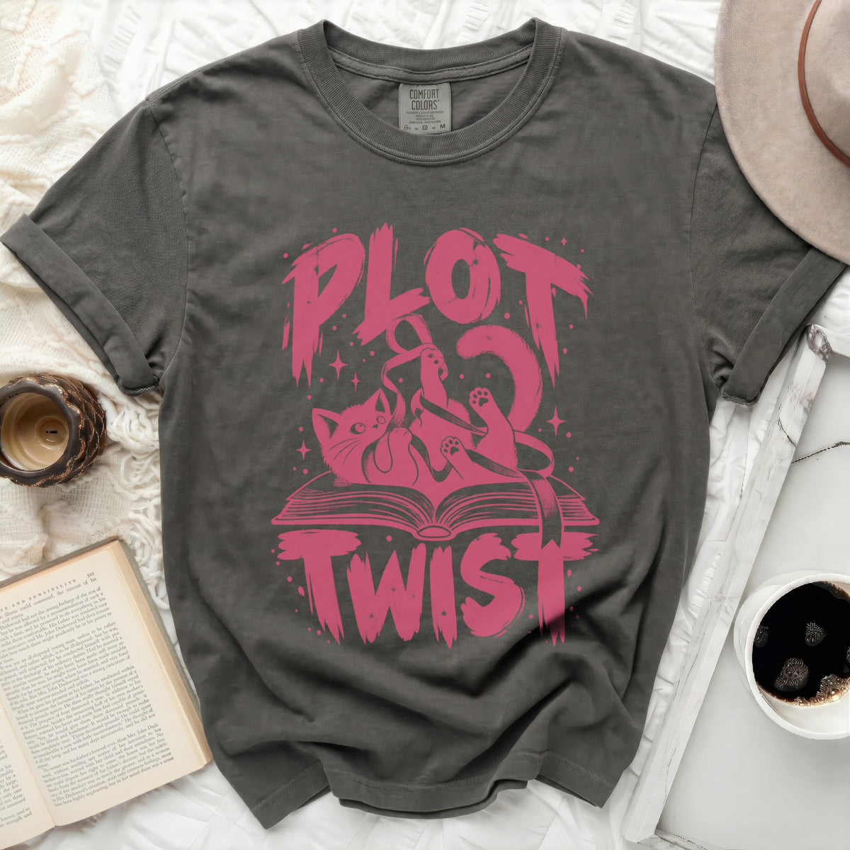 Dark grey t-shirt with pink "PLOT TWIST" text and a cat on a book.