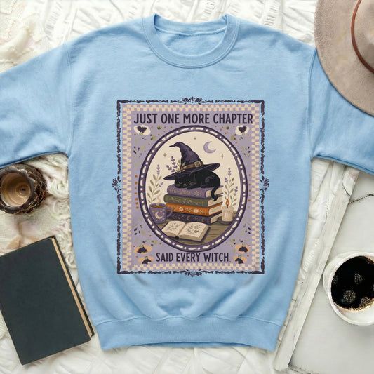Light blue sweatshirt with a graphic of a black cat, witch hat, books, and text.