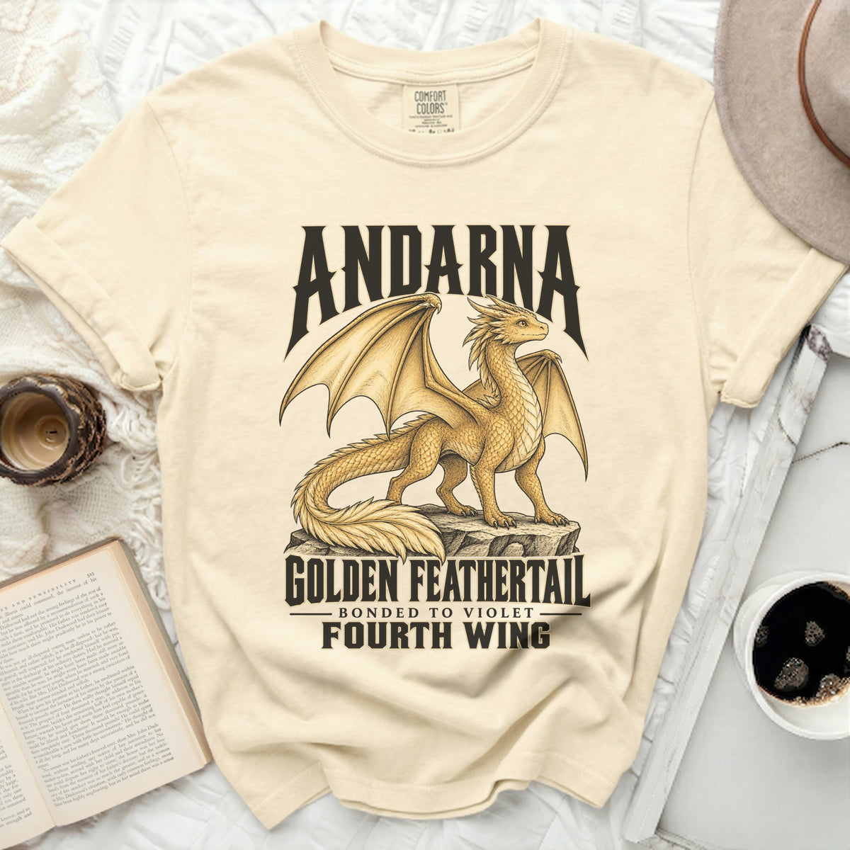 Cream t-shirt with a golden dragon graphic and text: Andarna, Golden Feathertail, Bonded to Violet, Fourth Wing.