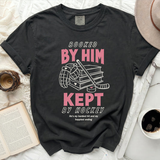 Black t-shirt with "Booked By Him, Kept By Hockey" text and graphics.