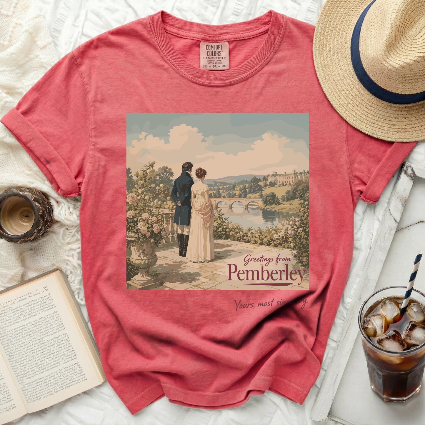 Coral t-shirt with "Greetings from Pemberley" print featuring a couple and estate.