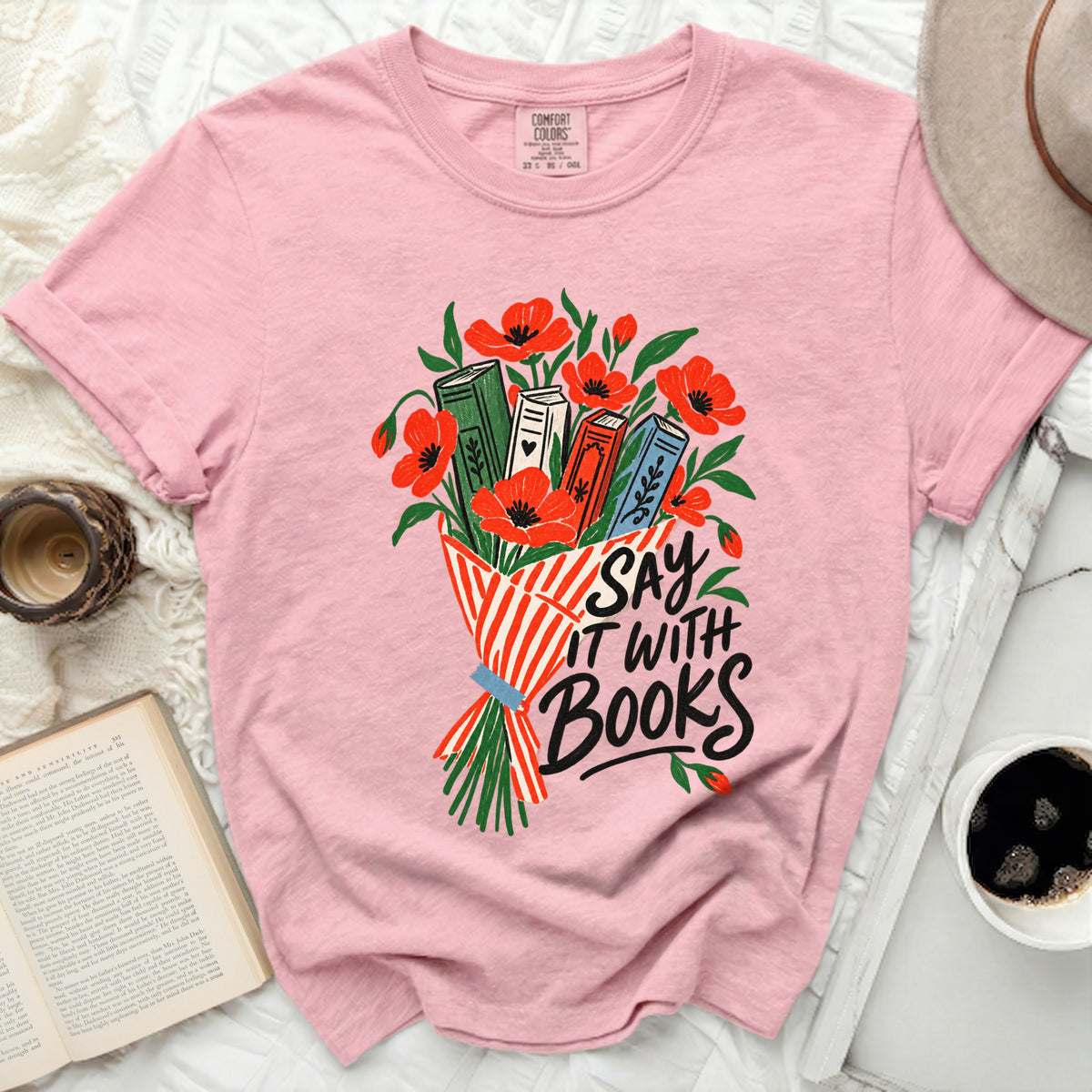 Pink t-shirt with graphic of books, poppies, and text "SAY IT WITH BOOKS".