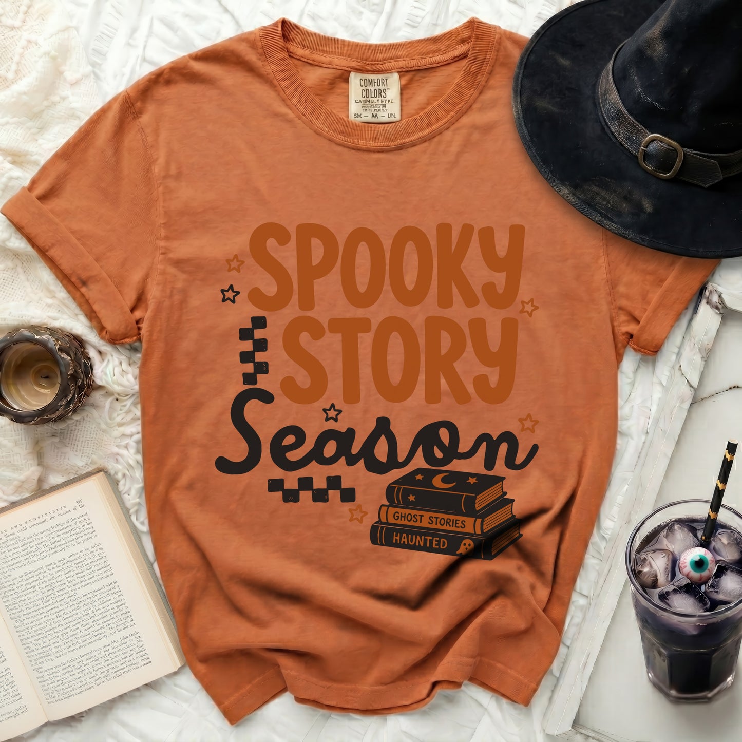 Orange t-shirt with "Spooky Story Season" text and stacked books.