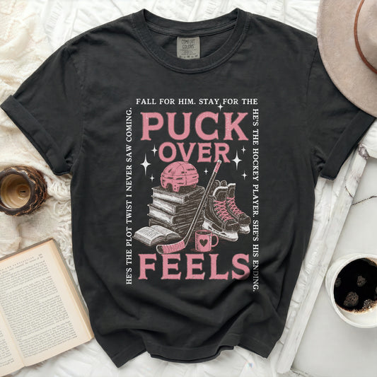Black t-shirt with "Puck Over Feels" graphic and hockey imagery.