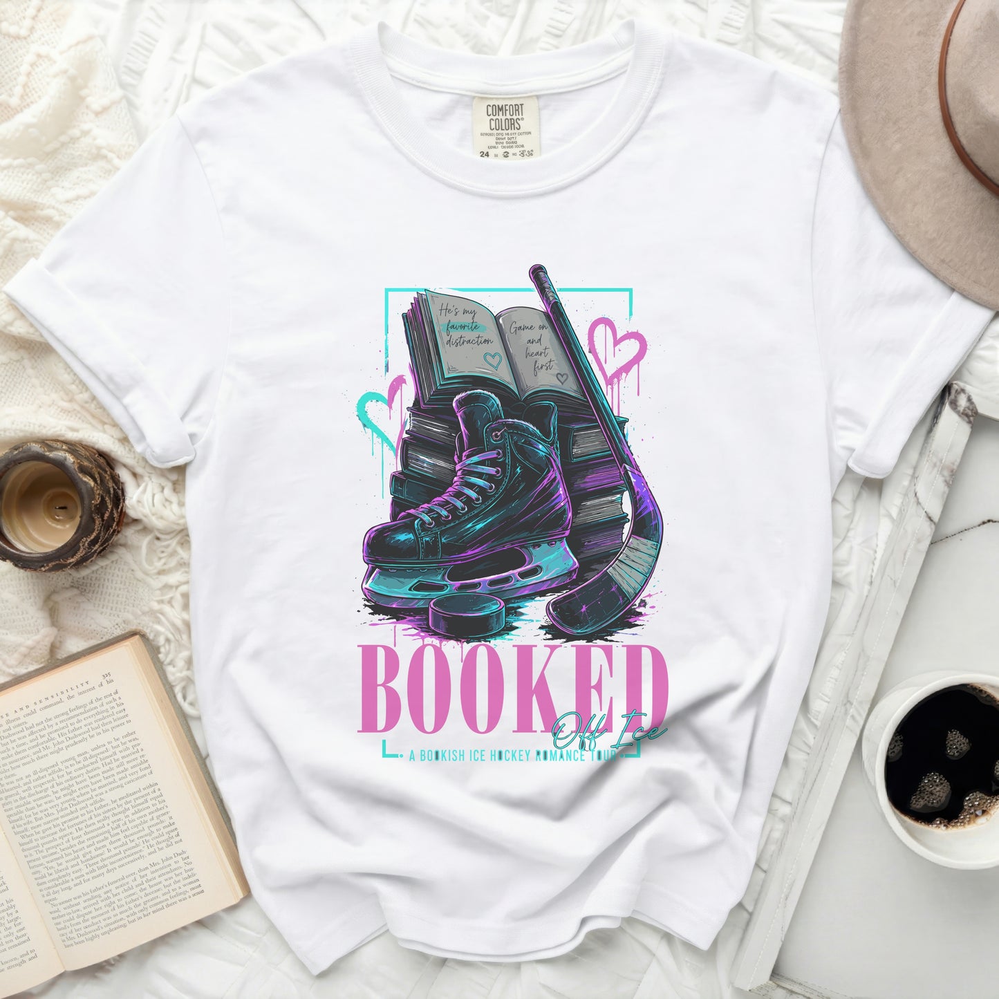 White t-shirt with "Booked" text, ice skates, books, and hockey stick.