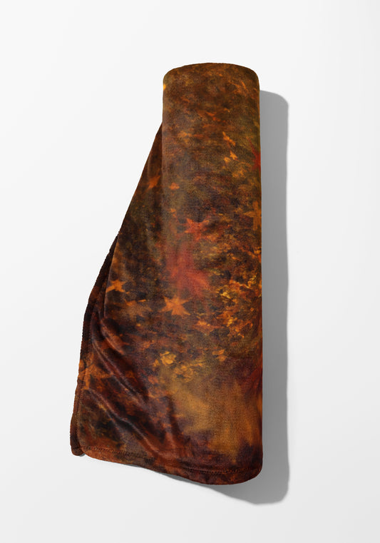 Rolled brown and orange fuzzy blanket with a star pattern.