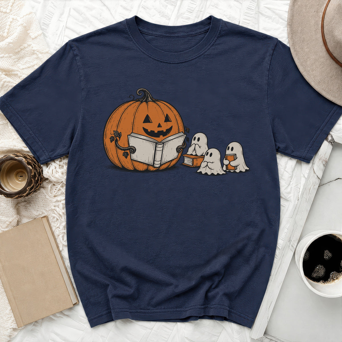 Jack-o'-lantern reads a book to two ghosts on a navy t-shirt.