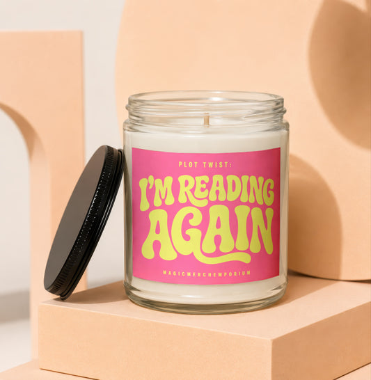 Candle with pink label reading "Plot Twist: I'm Reading Again."
