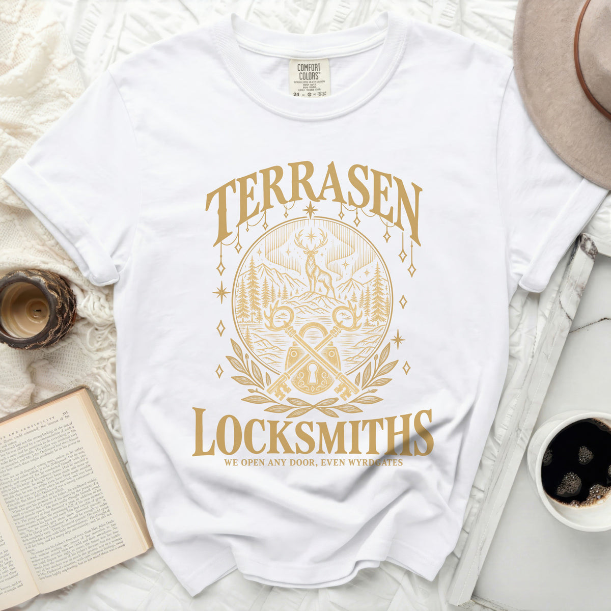 White t-shirt with gold text and graphic: TERRASEN LOCKSMITHS, WE OPEN ANY DOOR, EVEN WYRDGATES.