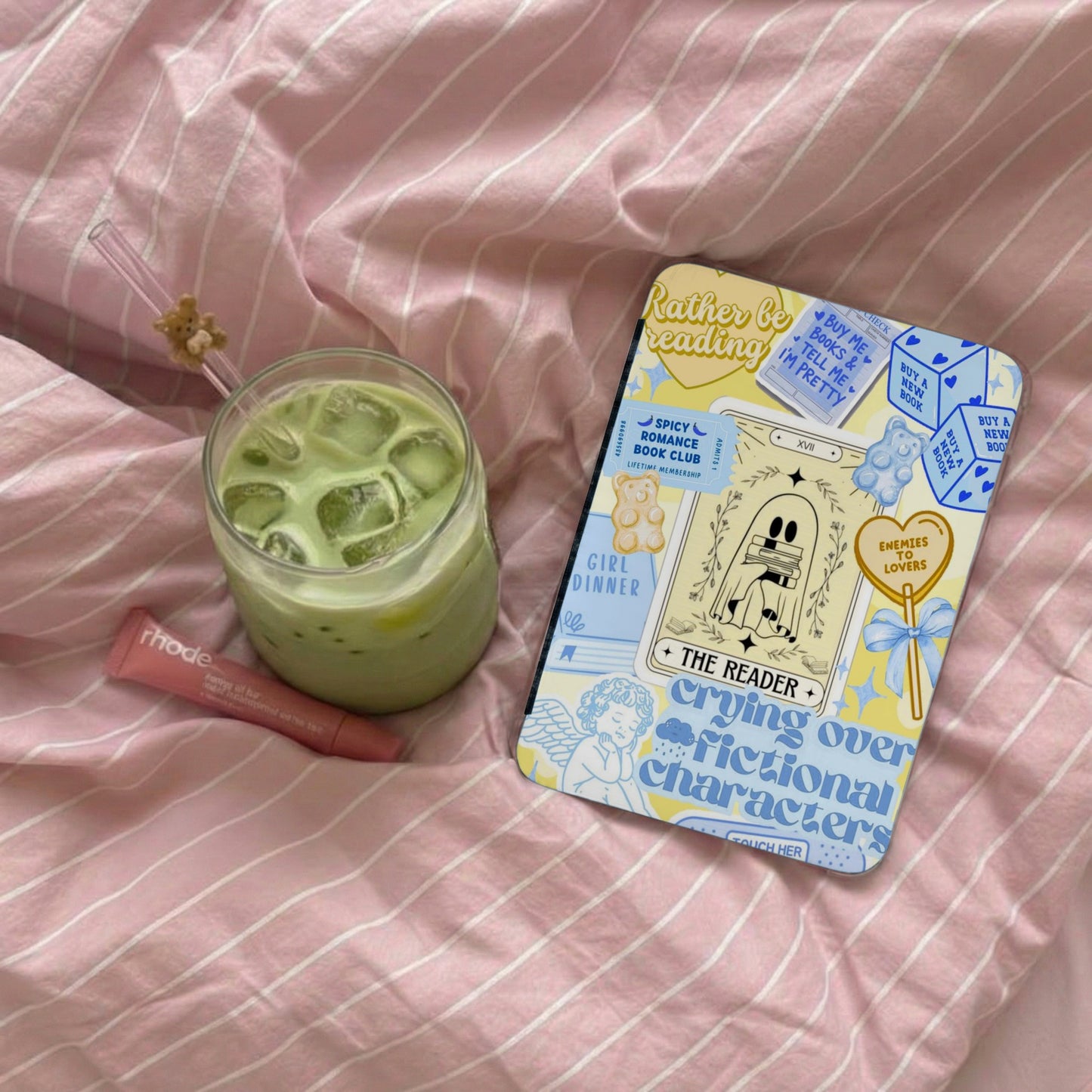 Phone case with "Rather be reading" design and cup of matcha drink.