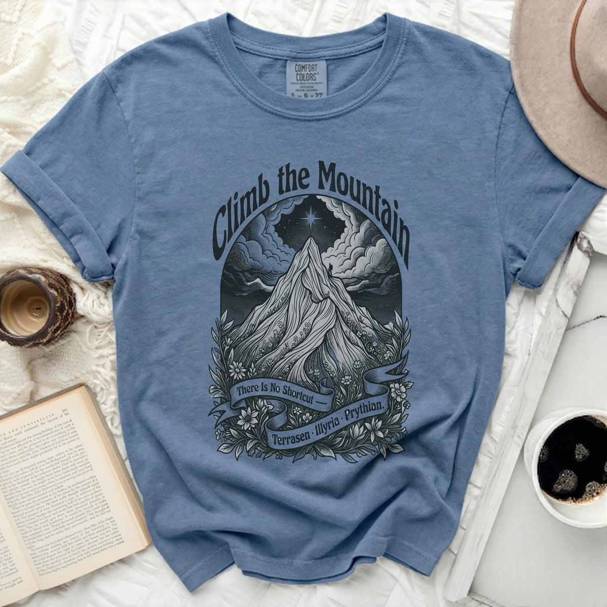 Blue t-shirt with a mountain graphic and text "Climb the Mountain, There Is No Shortcut, Terrasen Illyria. Prythian."