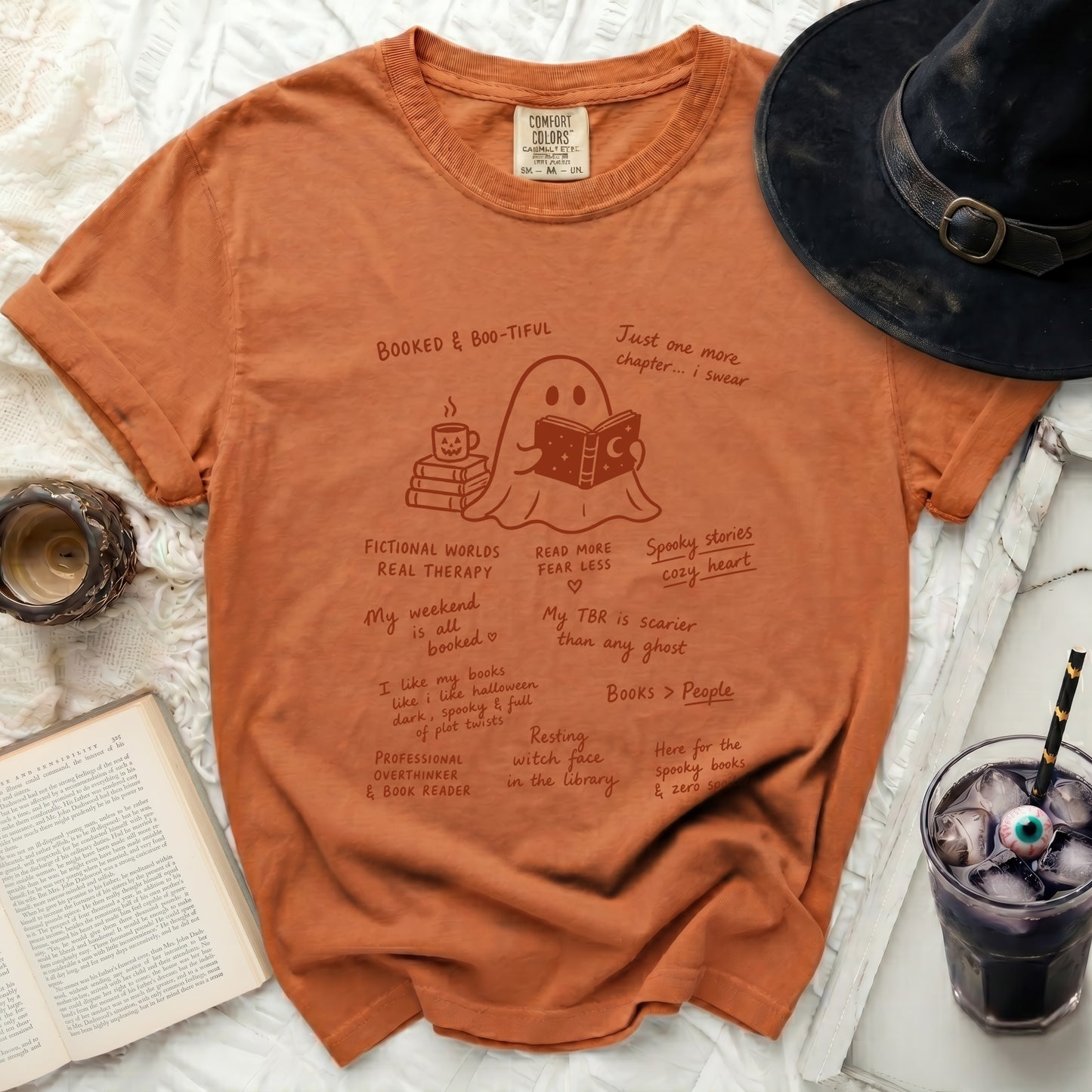 Orange t-shirt with ghost reading book illustration and book-themed text.